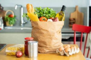 Grocery list for clean eating 2025 with fresh fruits, vegetables, and whole foods displayed on a kitchen counter.
