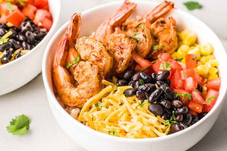 Healthy family dinner prep bowls with pasta, shrimp tacos, and colorful vegetables.