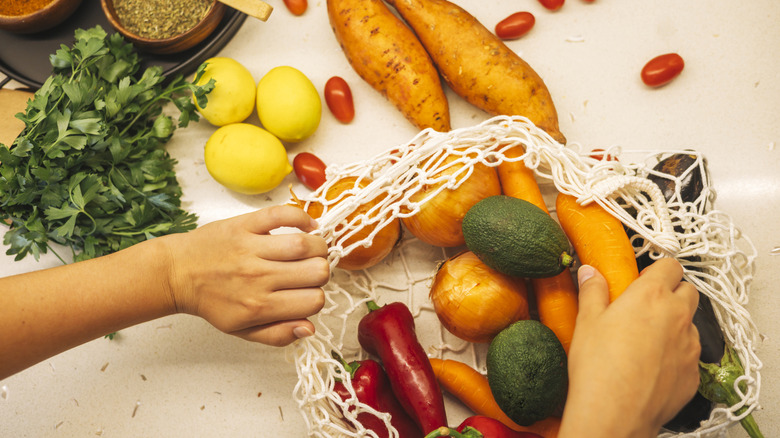 Root vegetables like carrots and beets stored in fridge with tops removed.