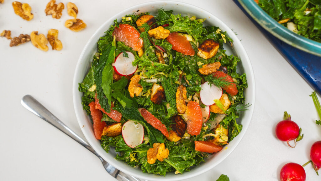 Work-friendly healthy lunch idea with kale salad, lentils, and halloumi in a meal prep container.